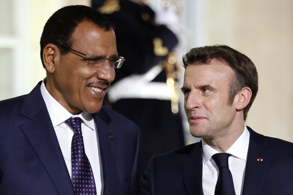 France's President Emmanuel Macron (R) welcomes Niger's President Mohammed Bazoum (since deposed in a coup) ahead of a meeting on the Sahel with leaders from the region, in Paris, 16 February 2022 (AFP)
