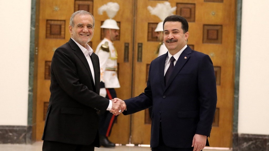 Iraq's Prime Minister Mohamed Shia al-Sudani (R) greets Iran's President Masoud Pezeshkian ahead of their meeting in Baghdad on 11 September (Ahmed Jalil/AFP)