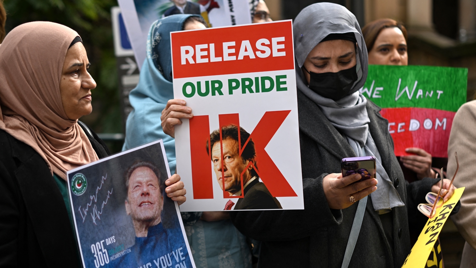 Supporters of Pakistan's jailed former prime minister Imran Khan hold placards during a protest rally in Sydney, Australia, on 4 August, demanding his release (Saeed Khan/AFP)