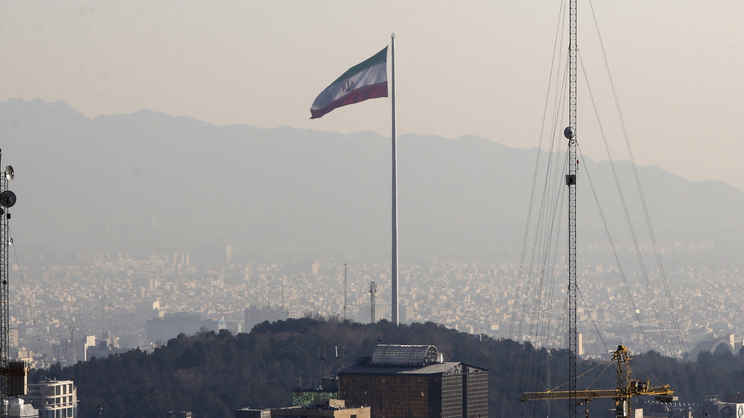 A general view shows the Iranian capital Tehran on 7 January 2023, with the Iranian flag fluttering in the wind (AFP)