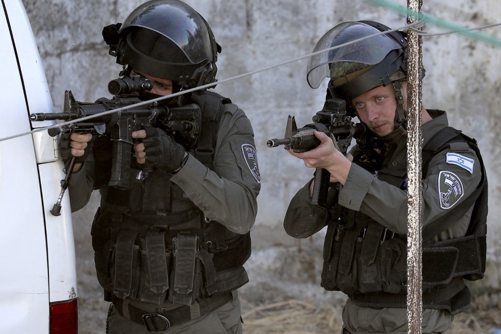 Israeli border guards raid a house in Rummanah, in the occupied West Bank, reportedly the home of a Palestinian man suspected of carrying out a fatal axe attack in the central city of Elad two days earlier (AFP)