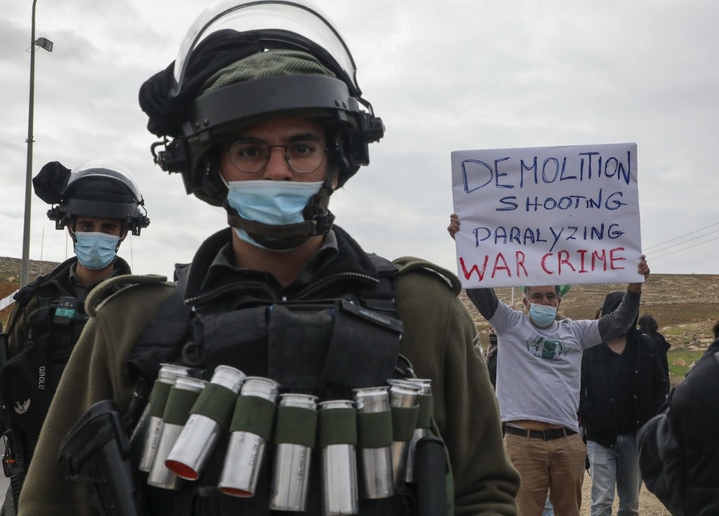 Israeli soldiers deployed as Palestinian and left-wing Israeli protesters demonstrate against settlements and land confiscation, south of Hebron city on 15 January 2021