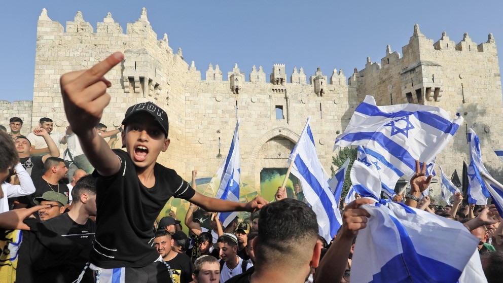 Demonstrators gather with Israeli flags during the so-called Jerusalem Day flag march outside the old city's Damascus Gate on 29 May 2022 (Gil Cohen-Magen/AFP)