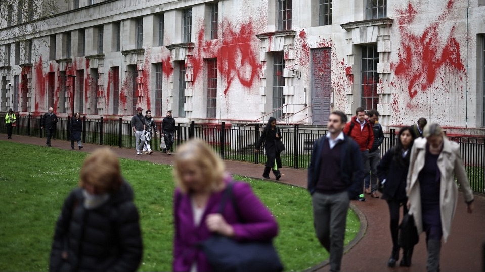 People walk past the Ministry of Defence, London, after protesters had spayed red paint onto it to demand UK political parties impose an arms embargo on Israel, 10 April 2024 (Henry Nicholls/AFP)