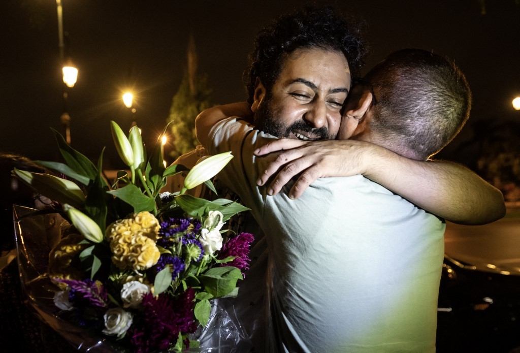 Moroccan journalist Omar Radi (left) hugs his friend after leaving prison in Rabat on 29 July (Fadel Senna/AFP)