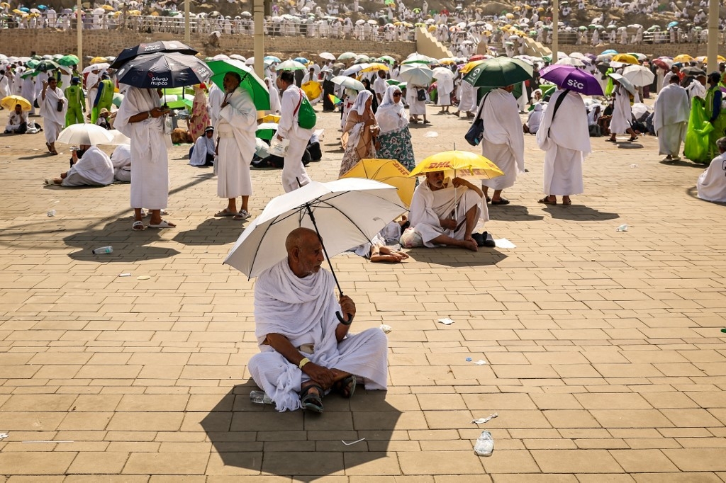 Muslim pilgrims use umbrellas to shade themselves from the sun as they arrive at the base of Mount Arafat during the annual Hajj pilgrimage on 15 June 2024 (Fadel Senna/AFP)