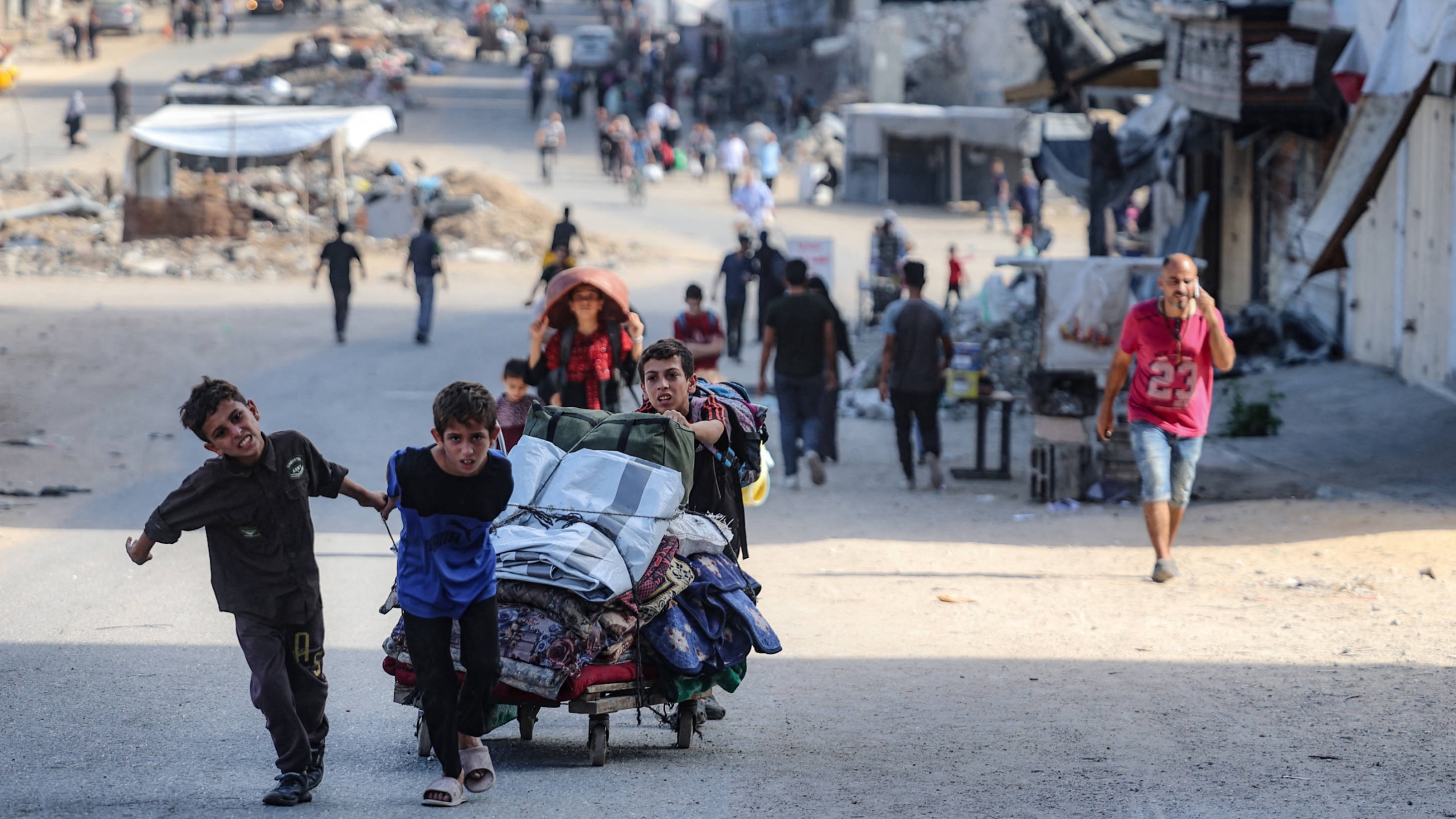 Palestinians carry their belongings as they flee areas north of Gaza City in the northern Gaza Strip on 12 October 2024 (AFP)