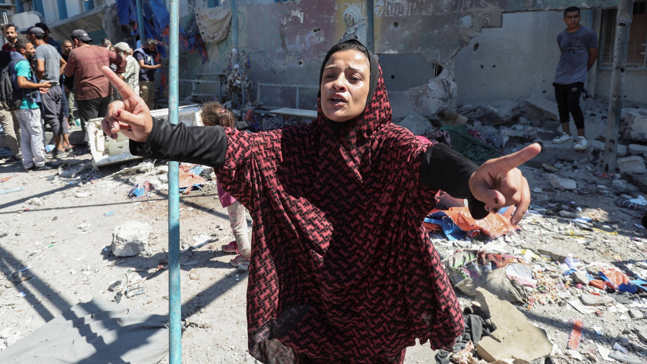 A displaced Palestinian woman reacts at a UN school used as a shelter by displaced families, following an Israeli strike in Nuseirat in the central Gaza Strip on 16 July 2024 (Reuters)