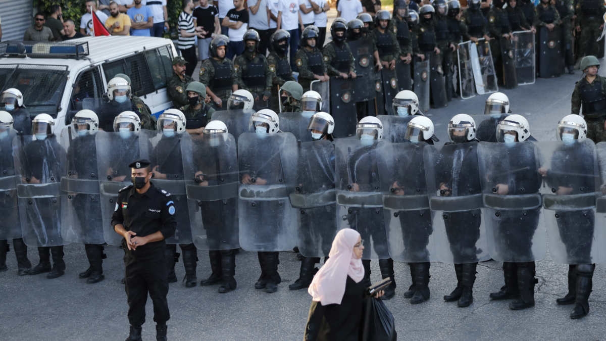 Members of the Palestinian Authority security forces block a road as demonstrators rally in Ramallah in the occupied West Bank on 3 July 2021 (AFP)