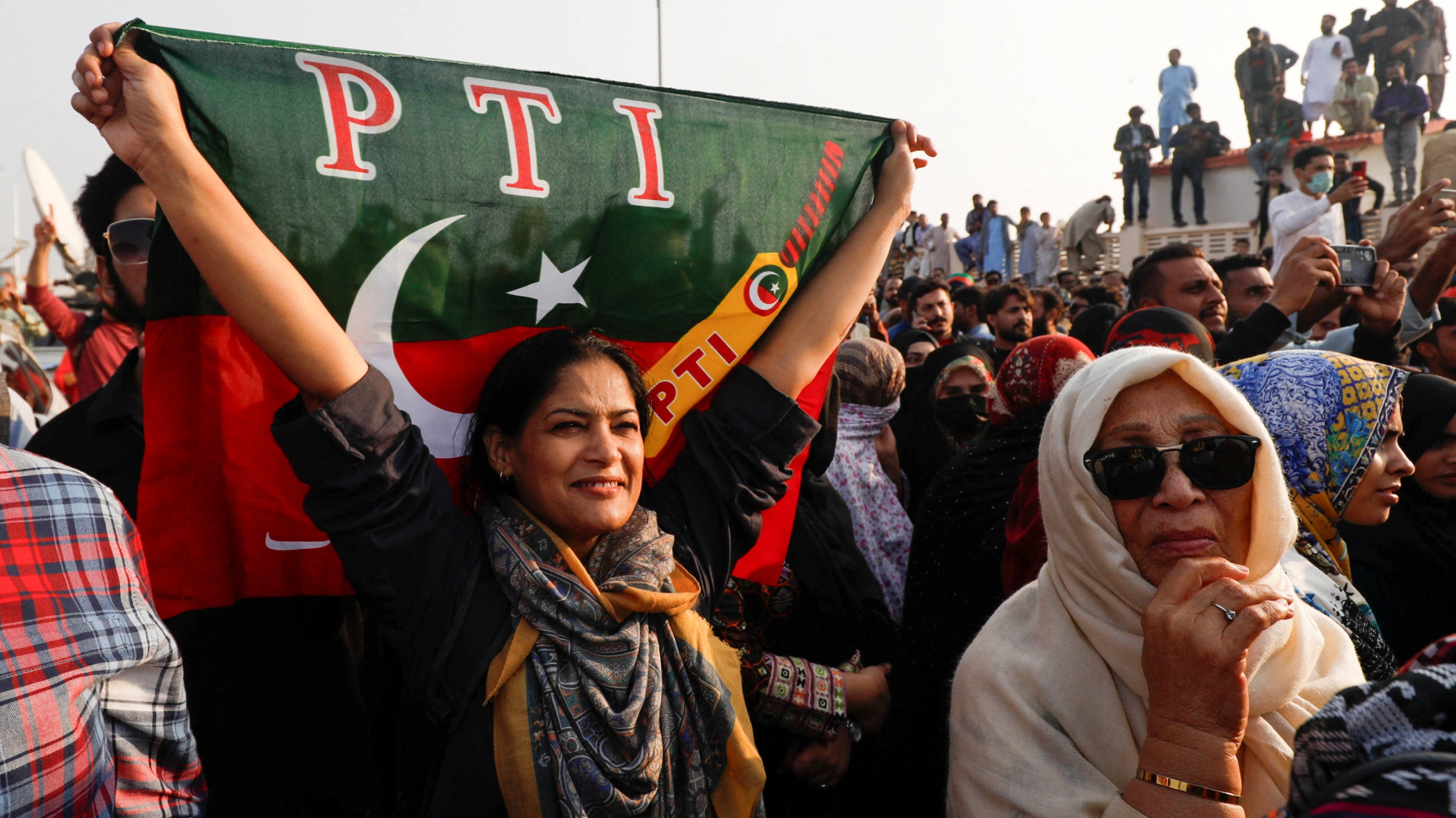 A supporter of Imran Khan's party, Pakistan Tehreek-e-Insaf (PTI), waves the party flag during a rally ahead of the general elections in Karachi, Pakistan 14 January 2024 (Reuters)