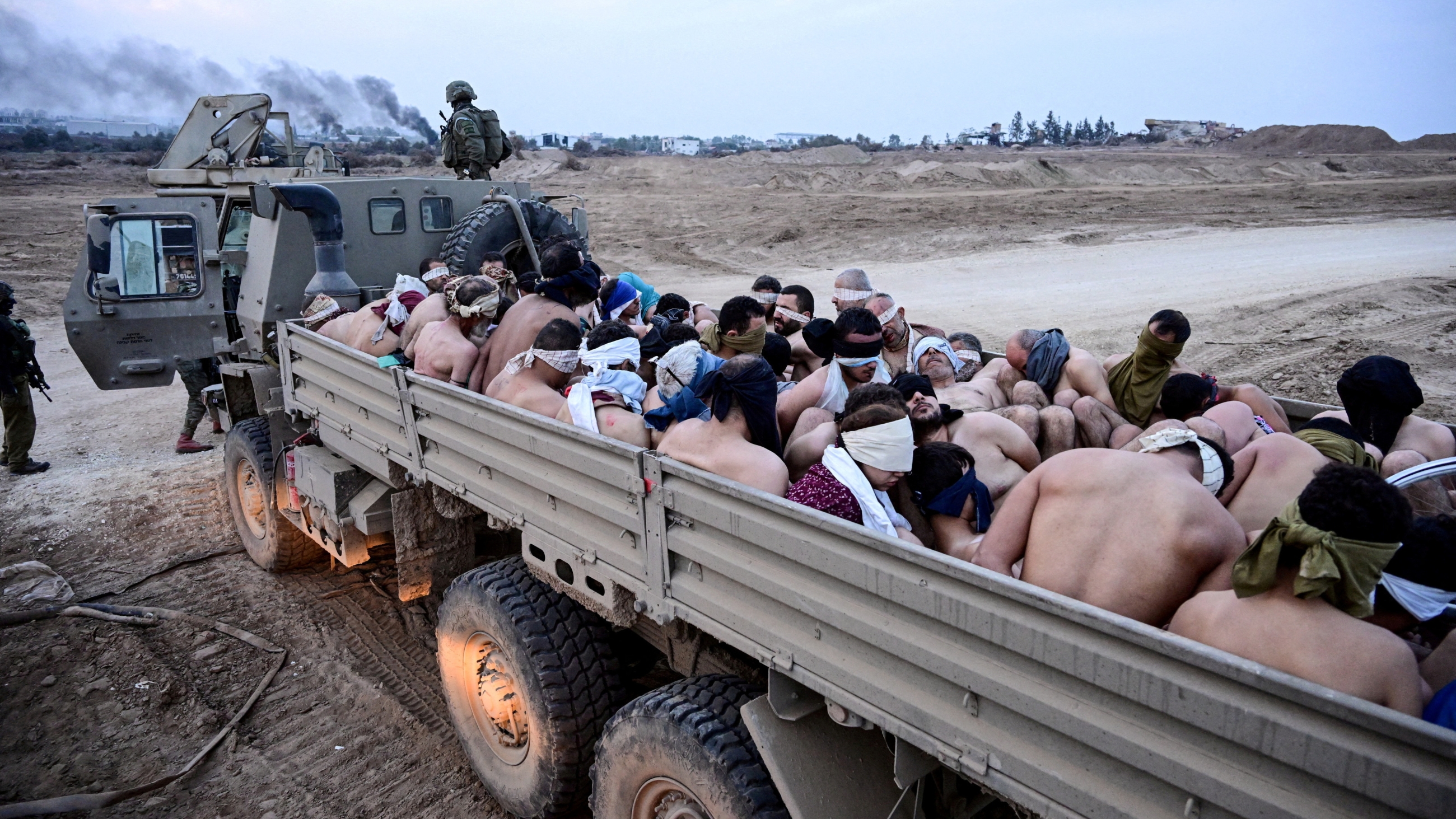 Les forces israéliennes transfèrent des Palestiniens arrêtés, les yeux bandés, dévêtus et menottés, le 8 décembre 2023 dans la bande de Gaza (Yossi Zelige/Reuters)