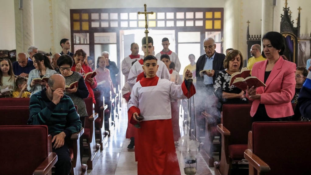 Palestinian Christians celebrate Easter Sunday Mass at the Catholic Holy Family Church in Gaza City, on 31 March 2024 (AFP)