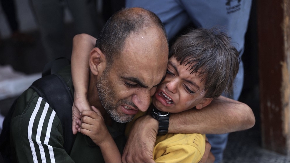 A Palestinian child is comforted following Israeli bombardment of a Gaza City neighbourhood, at al-Ahli Arab hospital, 4 July 2024 (Omar al-Qattaa/AFP)