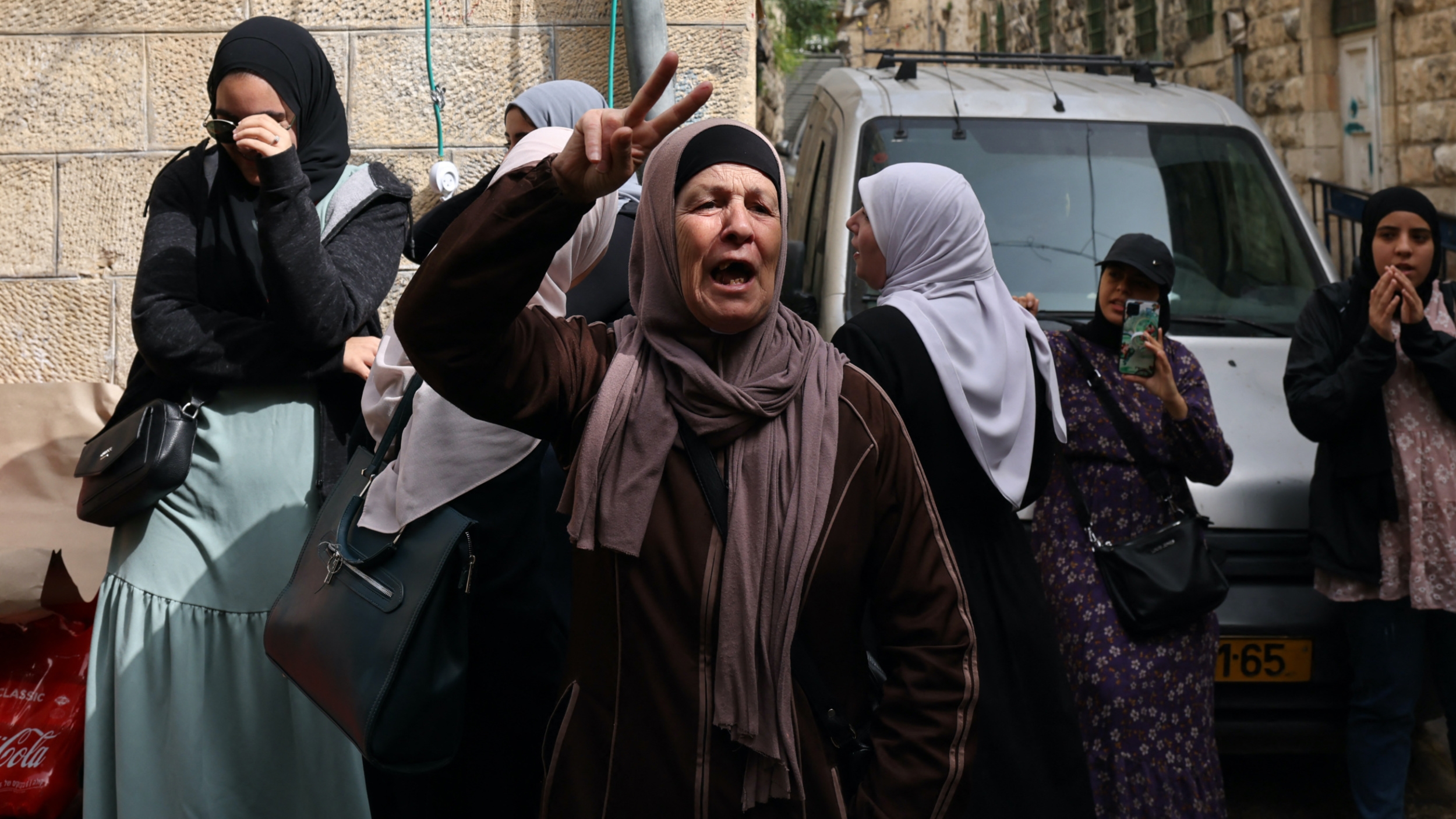 A Palestinian woman reacts as Israeli border police (unseen) patrol the area in front of the Lion's Gate in Jerusalem's Old City, on 17 April 2022 (AFP)