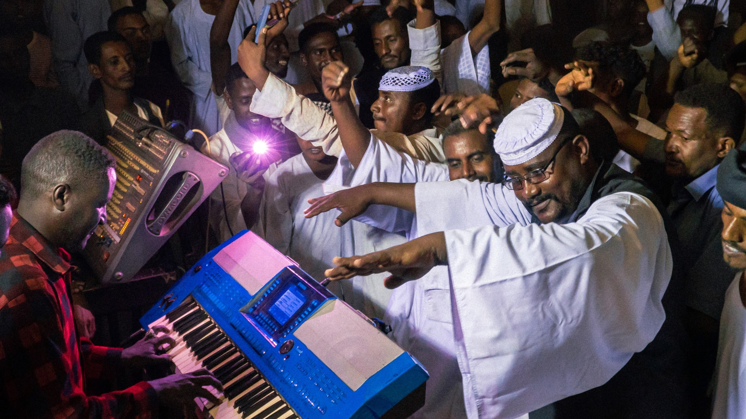 Sudanese men rave during a performance by Jantra