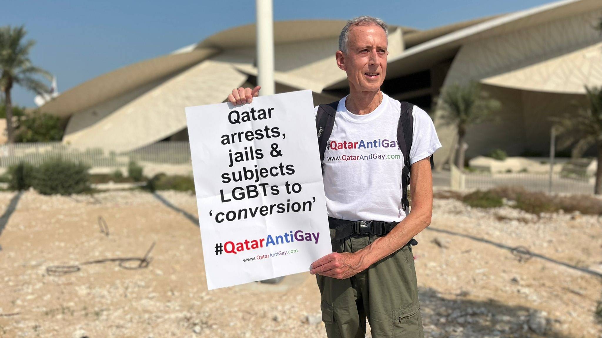 Peter Tatchell carrying a protest sign outside the National Museum of Qatar in Doha, 25 October 2022 (Twitter\Peter Tatchell)