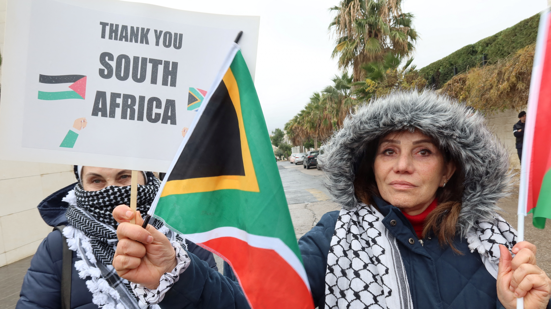 A demonstrator holds a South African flag in support of its case against Israel at the International Court of Justice (ICJ) in the Hague during a protest in Amman, Jordan, on 11 January 2024 (Jehad Shelbak/Reuters)