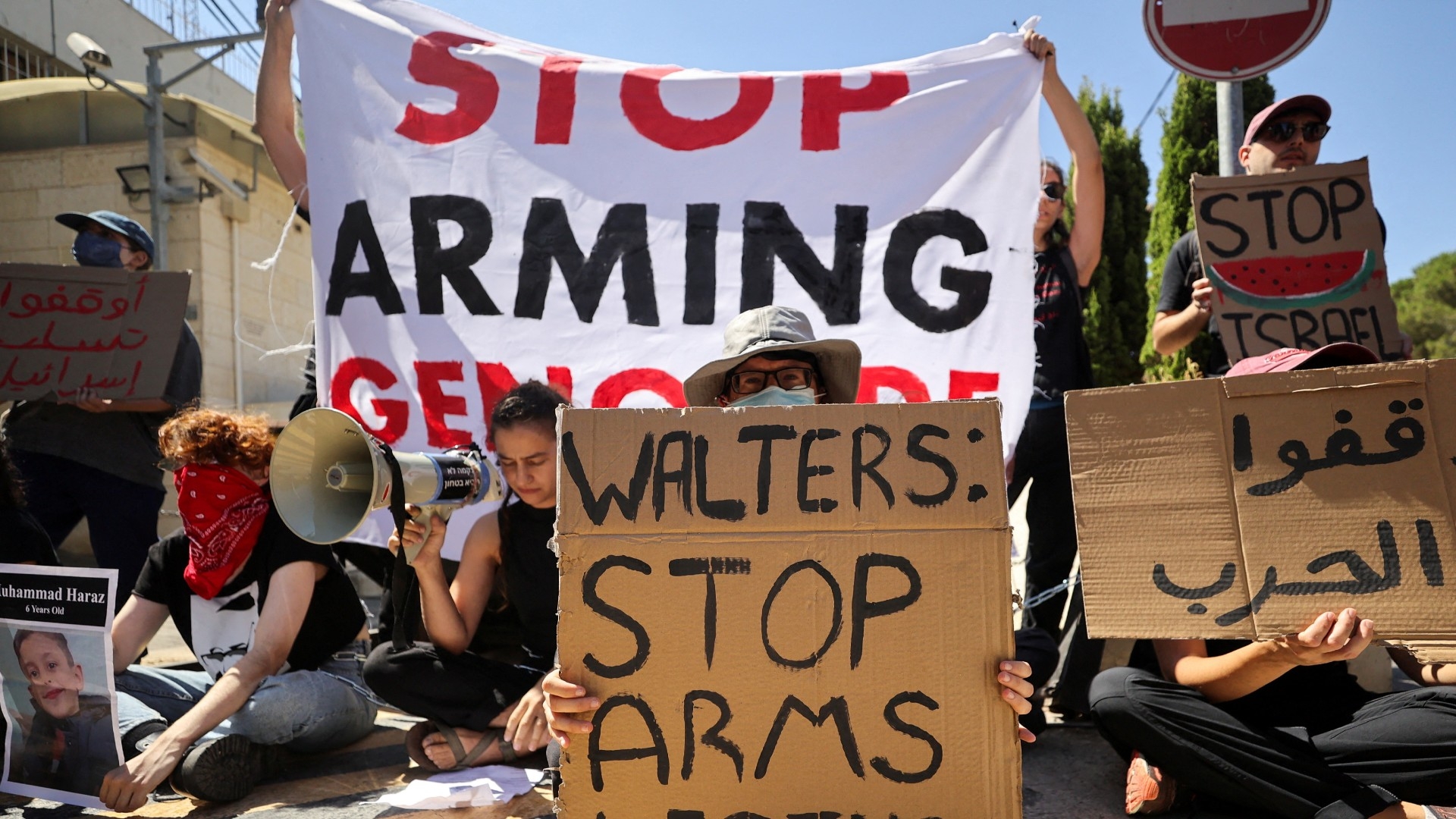 Chained Israeli protesters hold placards in a protest to call for an end to the war in Gaza, during Britain's Foreign Secretary David David Lammy's visit, in Jerusalem, 16 August (Reuters/Latifeh Abdellatif)