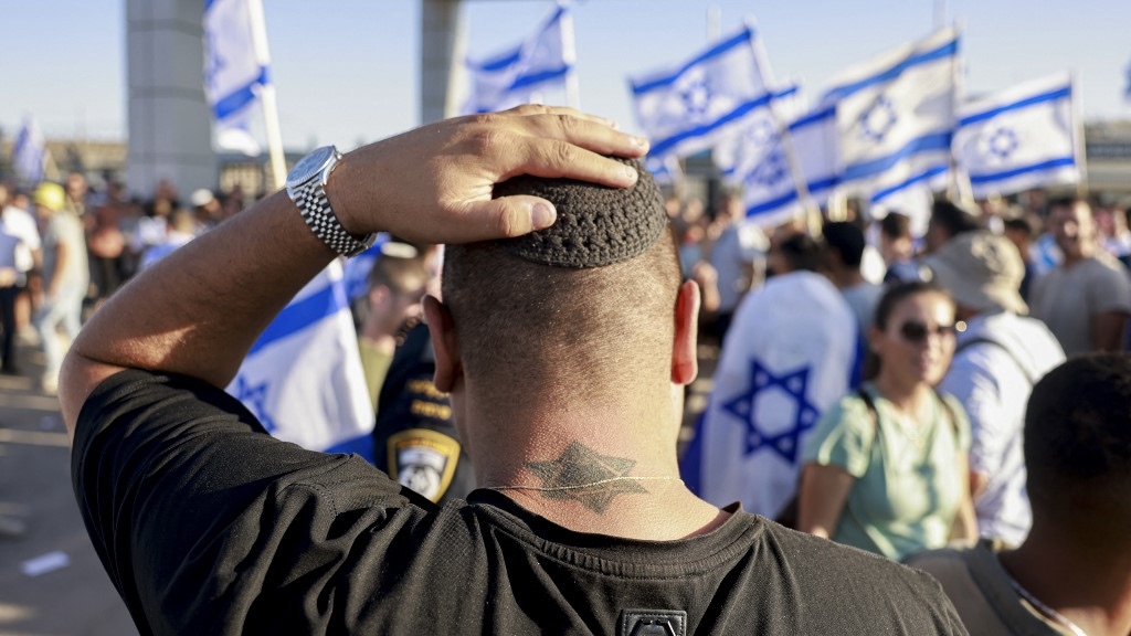 Right-wing Israelis demonstrate outside Sde Teiman camp near Beersheba against the detention of military reservists suspected of abusing Palestinian detainees, 29 July 2024 (Menahem Kahana/AFP)