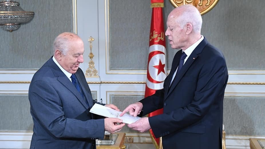 Sadeq Belaid, the head of the drafting committee, hands Tunisia President Kais Saied a draft of the constitution at Carthage Palace, 20 June 2022 (Twitter/Tunisian Presidency)