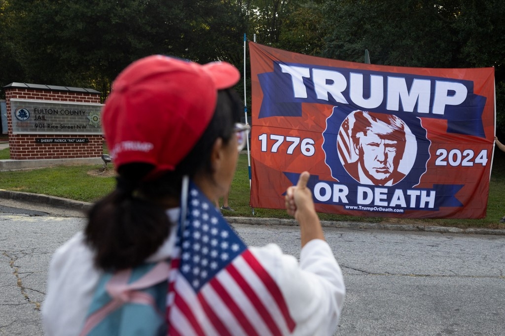 A supporter of former President Donald Trump outside the Fulton County Jail, Atlanta, Georgia, ahead of his expected arrival for indictment on 24 August 2023 (AFP)