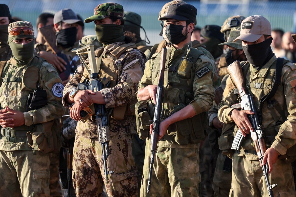 Military fighters affiliated  Hayat Tahrir al-Sham (HTS), attend prayers at an open air stadium on the first day of the Muslim Eid al-Adha holiday marking the end of the hajj pilgrimage to Mecca, in Idlib on June 16, 2024. (Omar Haj Kadour / AFP)