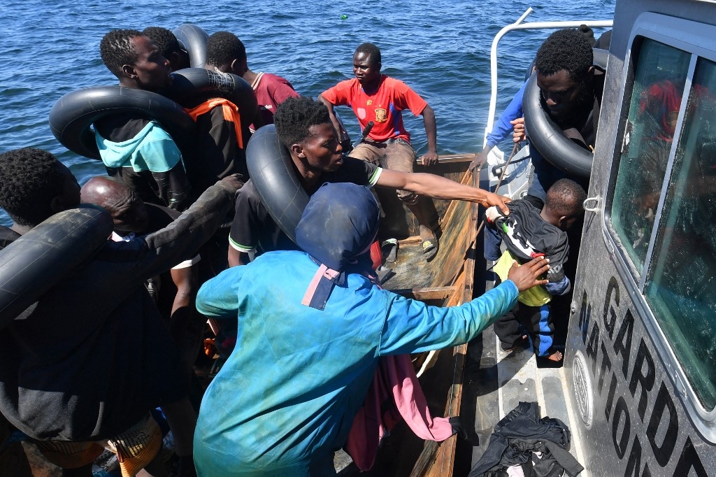 People trying to flee to Europe are transferred from their small boat onto a vessel belonging to the Tunisian National Guard, at sea between Tunisia and Italy, on 10 August 2023 (Fethi Balaid/AFP)