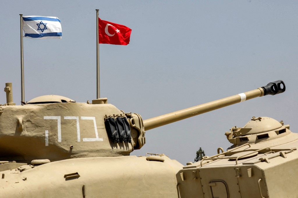 The flags of (L to R) Israel and Turkey fly behind M4A1 Sherman and AMX-13 battle tanks on display at the Yad La-Shiryon Tank Museum in Latrun, about 30 kilometres west of Jerusalem, on August 18, 2022.  (AFP)