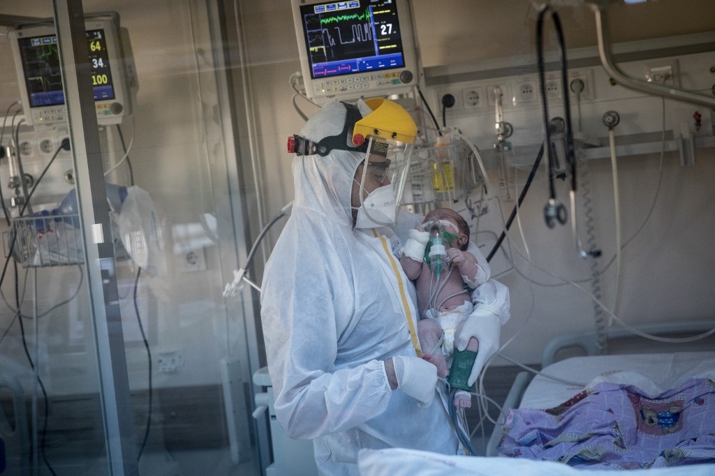 A medical worker assists a COVID-19 positive baby at a hospital Intensive Care Unit (ICU) on May 07, 2020 in Istanbul, Turkey. (Chris McGrath/ Getty Images via AFP)