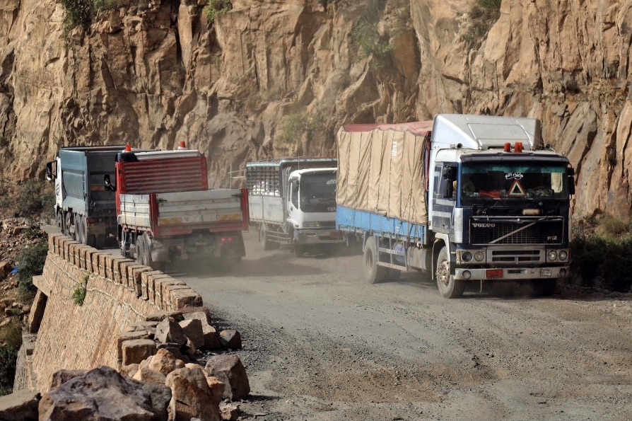 Trucks on a heavily damaged road between Yemen's cities of Taiz and Aden, 23 September 2020 (AFP)