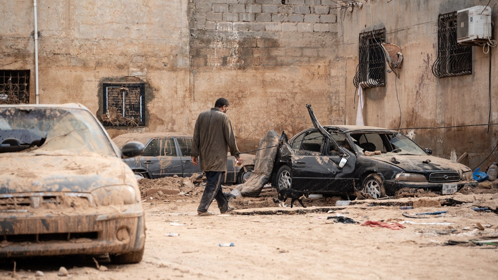 A man walks past his damaged house in Derna, Libya (MEE/Taha Jawashi)