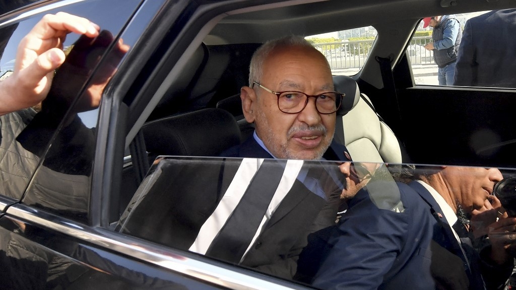 Ennahdha Rached Ghannouchi, the head of Tunisia's Islamist movement, greets supporters upon arriving at a police station in Tunis on 21 February 2023 (AFP)