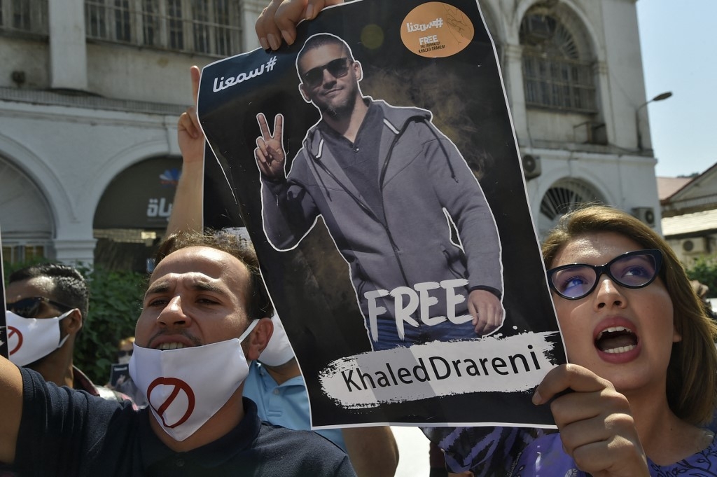 Algerians lift a portrait of journalist Khaled Drareni during a rally to protest his incarceration in the capital Algiers, on 7 September 2020.