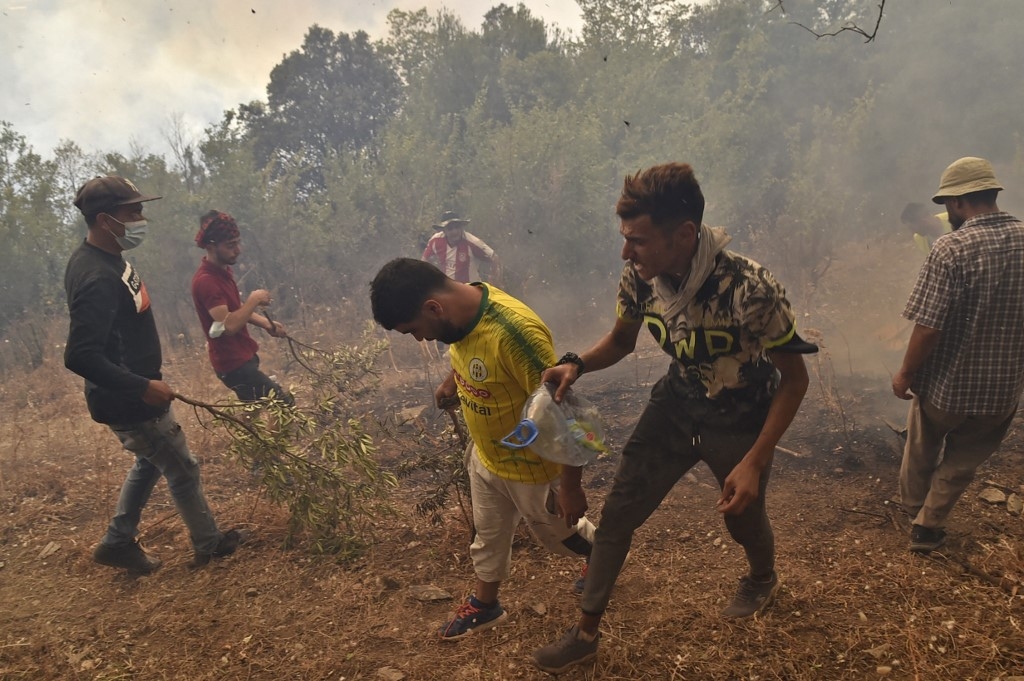 Des volontaires tentent de lutter contre les incendies en Kabylie, à l’est d’Alger, le 12 août 2021 (AFP/Ryad Kramdi)