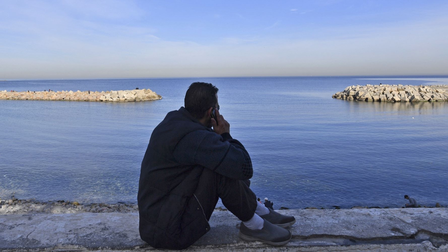 A man gazes at the Mediterranean Sea in the capital city of Algiers in January 2023 (AFP)