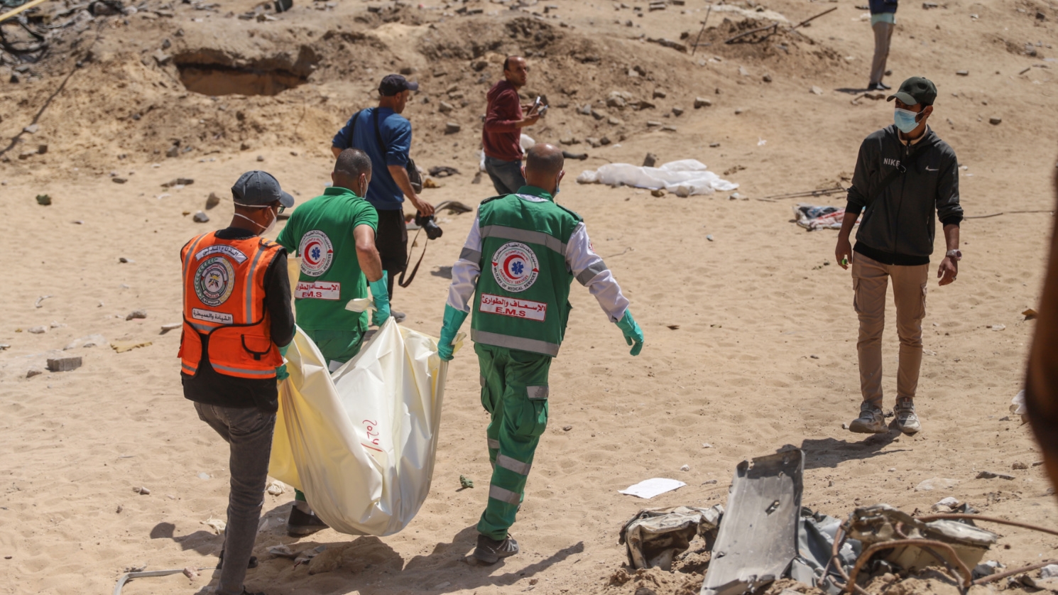 Emergency services and Civil Defence personnel carry one of the recovered bodies in al-Shifa Medical Complex in Gaza City on 8 April, 2024 (Mohammed al-Hajar/MEE)