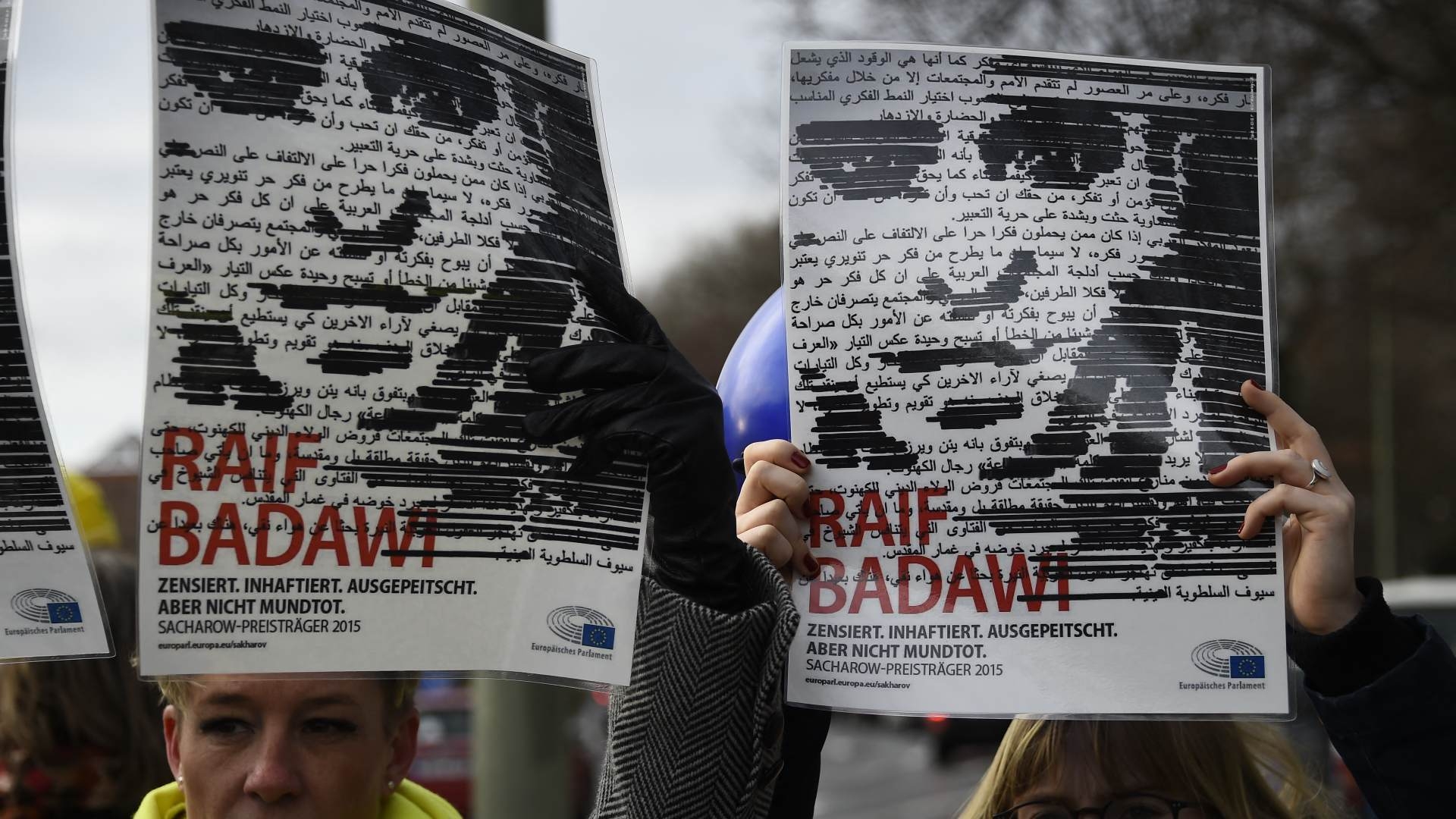 Members of Amnesty International hold up portraits of Saudi blogger Raif Badawi in front of the Saudi embassy in Berlin, on 8 January 2016.