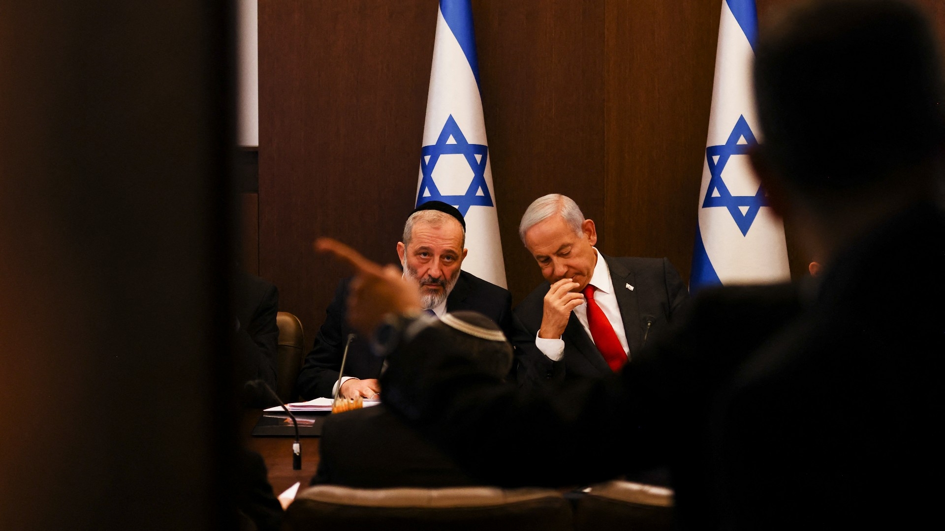 Israel's Prime Minister Benjamin Netanyahu sits next to Interior and Health Minister Aryeh Deri during a weekly cabinet meeting in Jerusalem on 8 January 2023 (AFP)