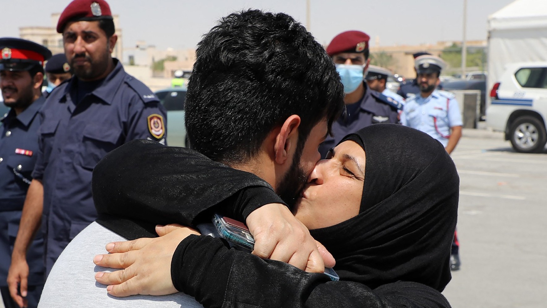 People embrace after scores of prisoners were released from a notorious jail following a royal pardon in Manama, Bahrain, on 5 September 2024 (AFP/BNA)