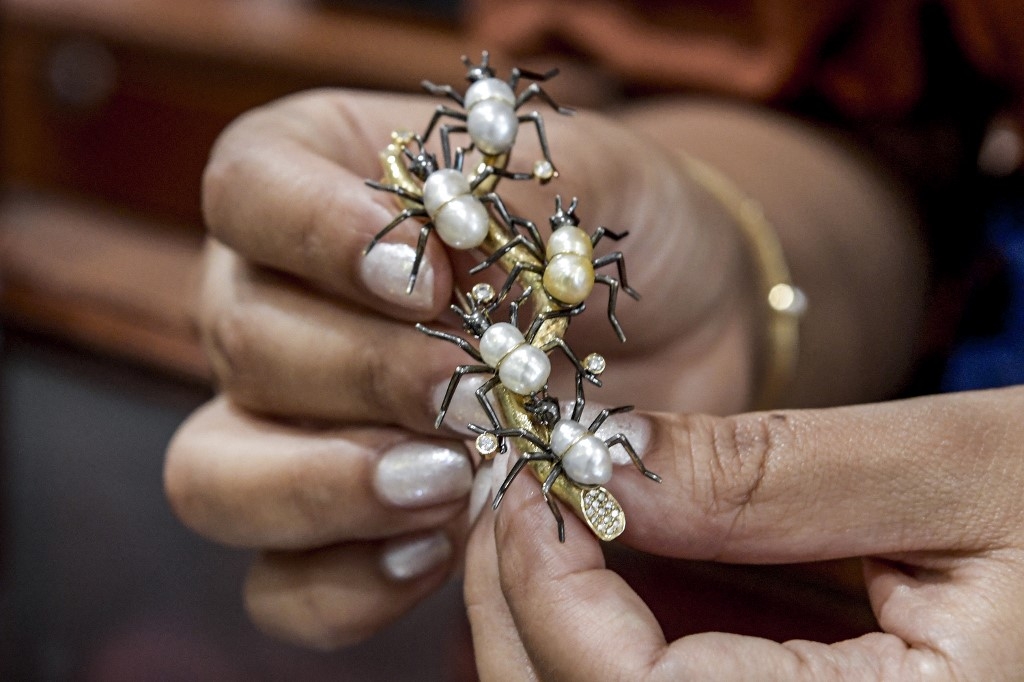 Une broche incrustée de petites perles similaires et pourtant toutes « uniques » (AFP/Mazen Mahdi)