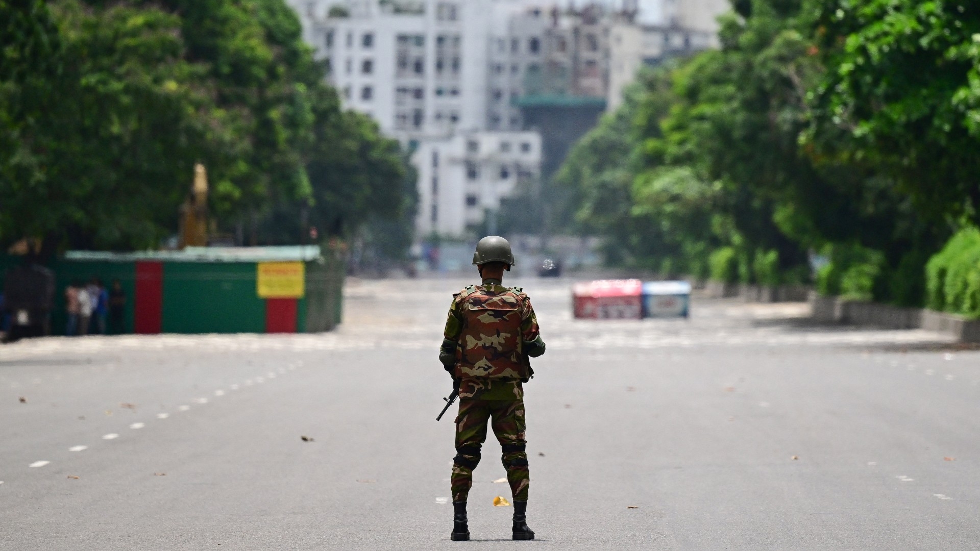 A Bangladeshi solider stands guard near the parliament following protests in Dhaka on 22 July 2024 (AFP/Munir Uz Zaman) 