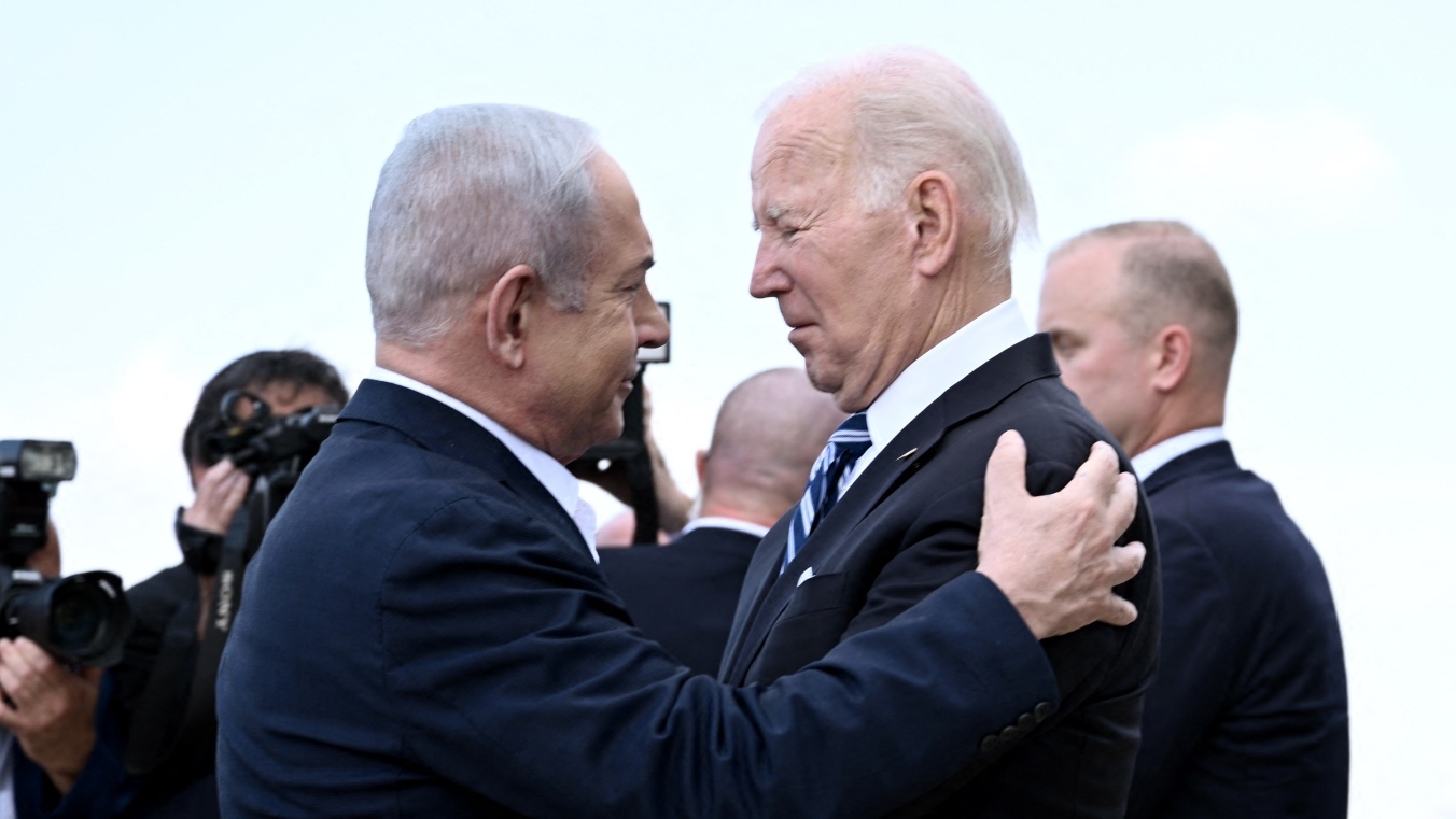 Israel Prime Minister Benjamin Netanyahu (L) greets US President Joe Biden upon his arrival at Tel Aviv's Ben Gurion airport on 18 October 2023.