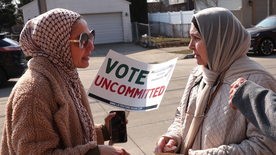 A Muslim organiser talks to voters outside of a polling location at Maples Elementary School on 27 February 2024 in Dearborn, Michigan.