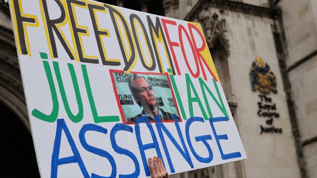 A protester holds a placard calling for the release of Wikileaks founder Julian Assange outside of Britain’s High Court in central London on 21 February 2024 (Adrian Dennis/AFP)