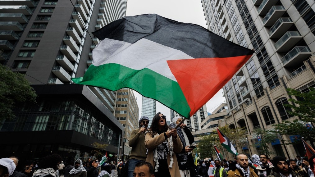 Demonstrators wave Palestinian flags during a protest in Toronto, Canada, on 9 October 2023 (Cole Burston/AFP)