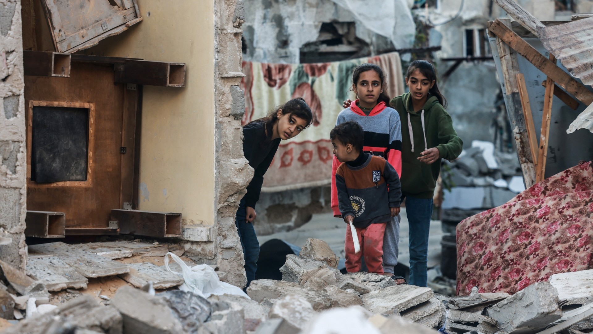 Children inspect the damage following Israeli bombardment in Rafah in the southern Gaza Strip on 29 December 2023 (AFP)