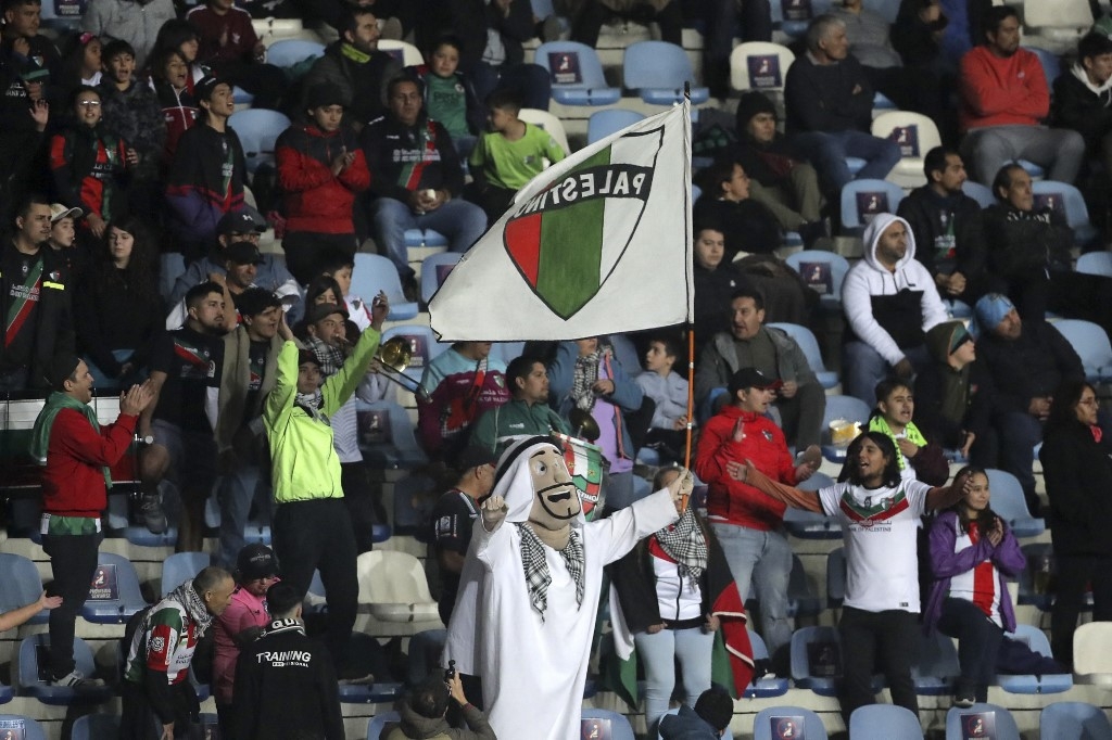 Francisco Muñoz applaudit son équipe Palestino portant le costume de la mascotte du club Palestina lors du match de la Copa Sudamericana contre Estudiantes de Merida à Rancagua, Chili, le 18 avril 2023 (AFP/Javier Torres)