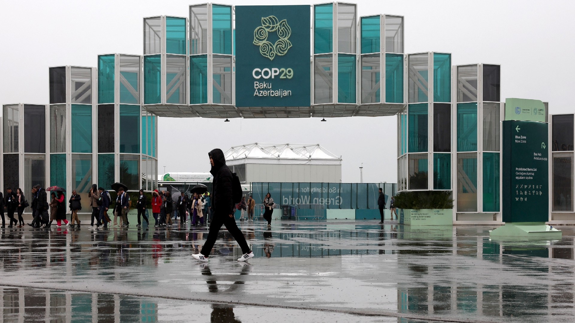 People walk at the entrance of the venue of the United Nations climate change conference COP29, in Baku, Azerbaijan November 18, 2024 (Reuters)