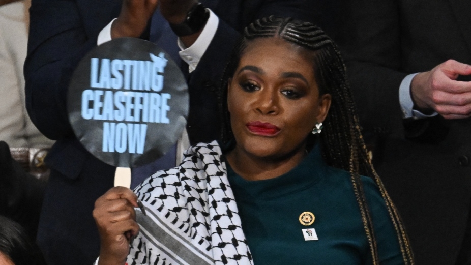 US Representative Cori Bush hold sign reading "Lasting Ceasfire Now" as US President Joe Biden delivers the State of the Union address in the House Chamber of the US Capitol in Washington on 7 March 2024.