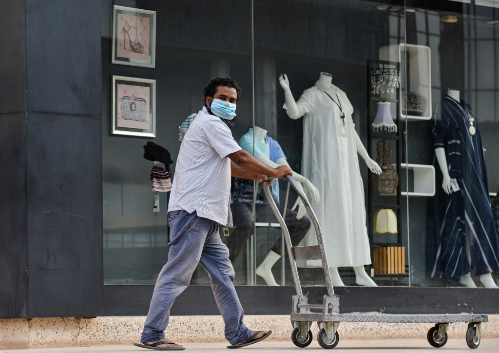 A Saudi worker wearing a mask passes a boutique shop. Riyadh reported more than 200,000 novel coronavirus cases.